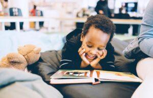 boy smiling and reading book